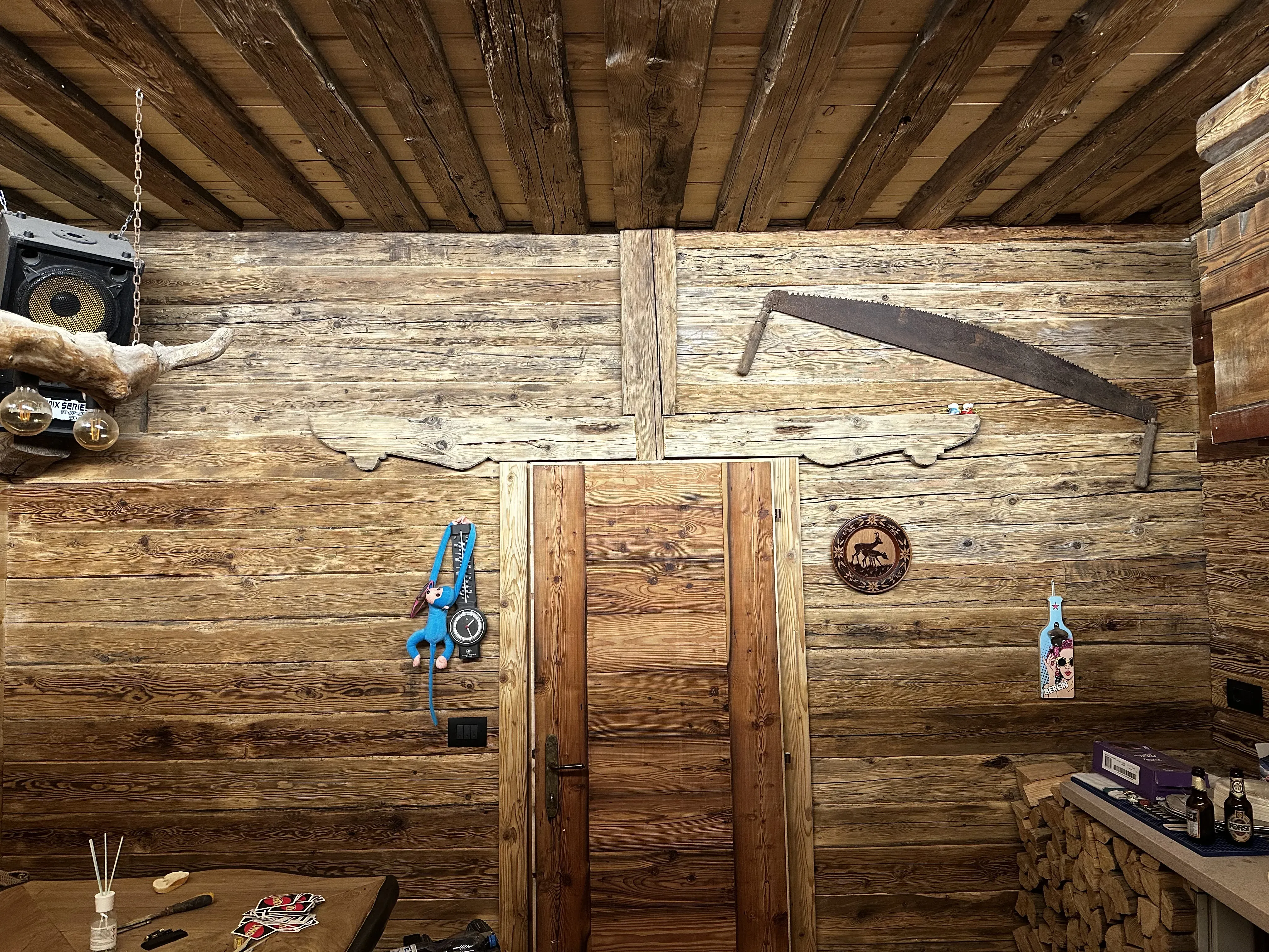 Parete rivestita in legno antico con porta e dettagli decorativi rustici