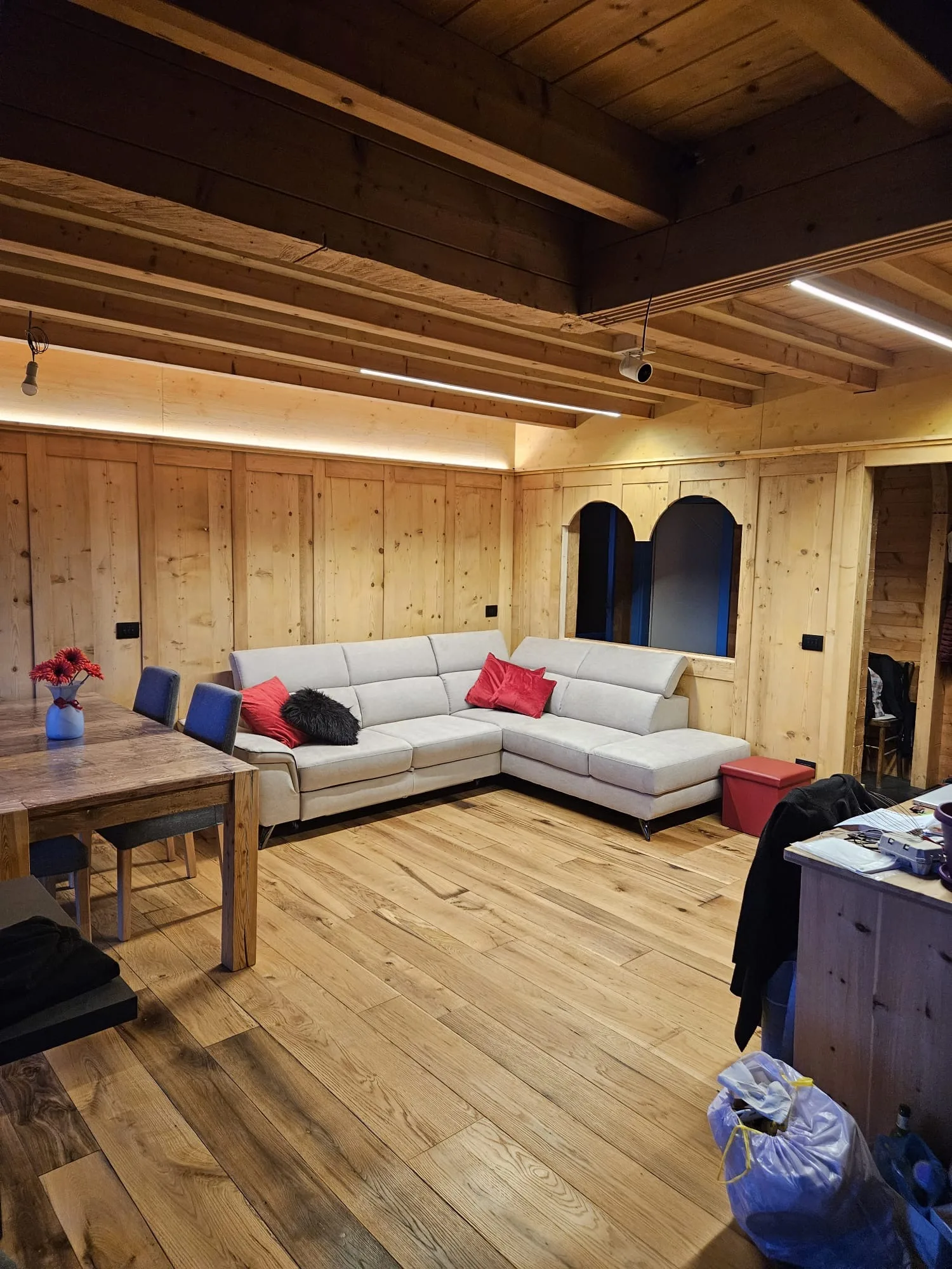 Soggiorno con pavimento in legno e divano ad angolo