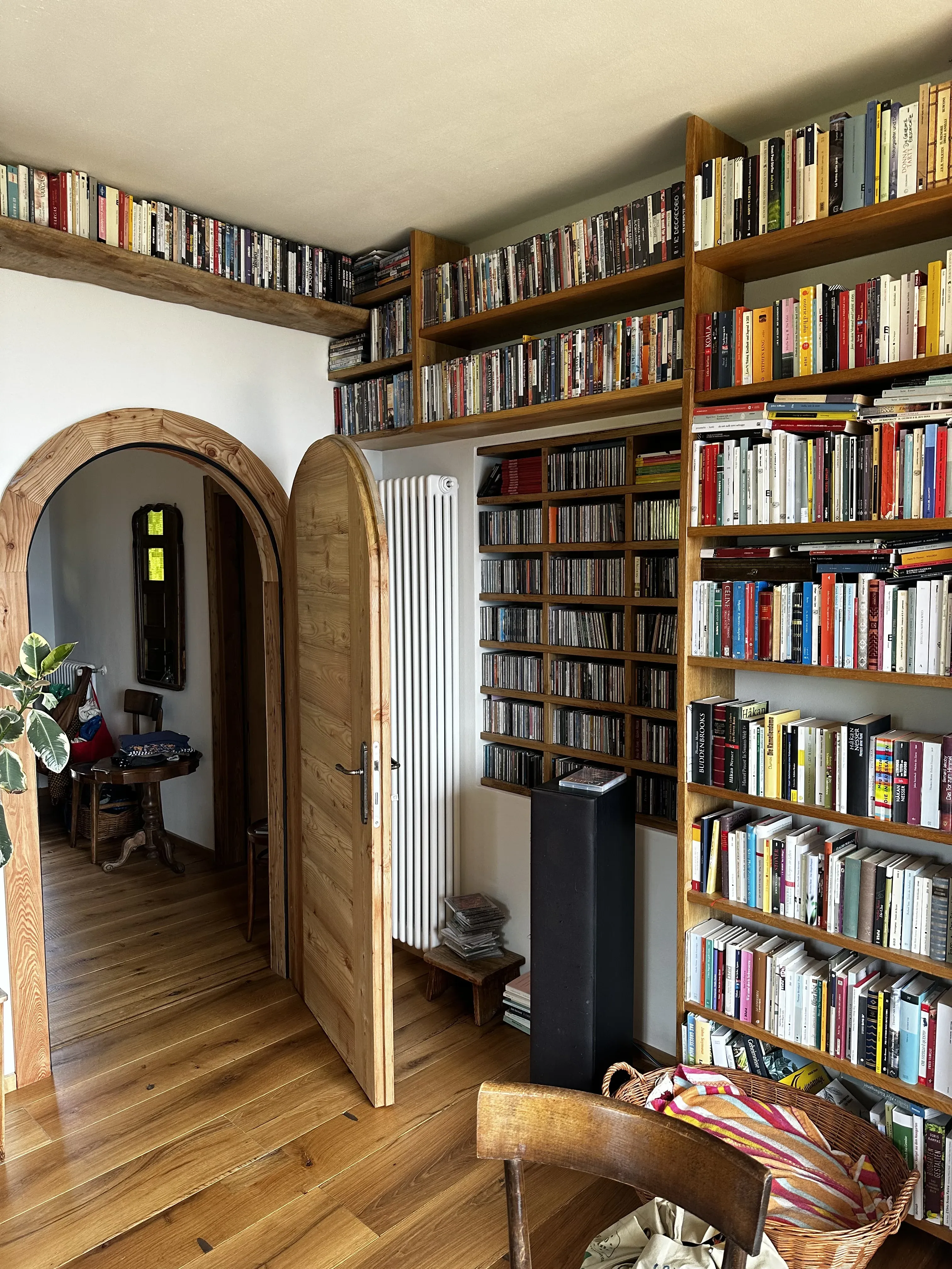 Libreria in legno con pavimento in legno e porta ad arco
